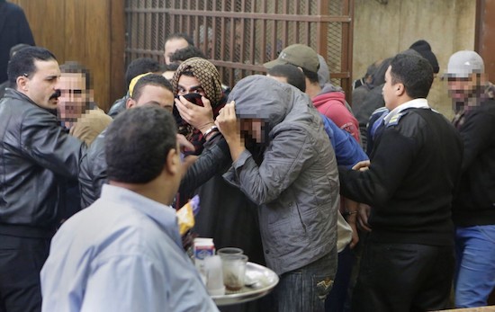 Hombres arrestados por policías que buscaban a homosexuales en un baño público de El Cairo esconden sus caras tras ser absueltos. Amir Nabil /Via AP