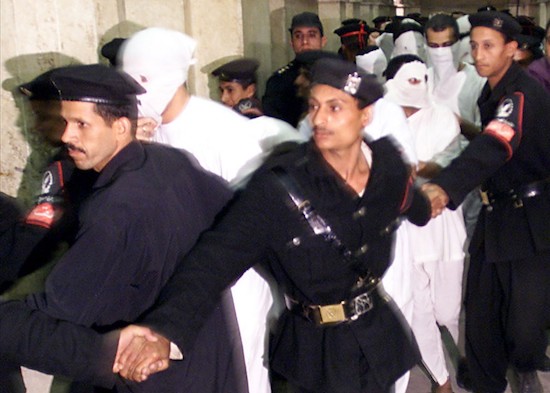 Oficiales especiales de policía llevan a algunos de los 52 presuntos homosexuales al juicio en un juzgado de El Cairo, Egipto, el 14 de noviembre de 2001. AP Photo/Philip Mark